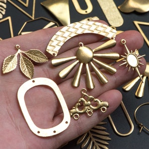May include: Assortment of gold-tone metal earring charms, including a sunburst design, a leaf design, a woven arch, and a rectangular frame.