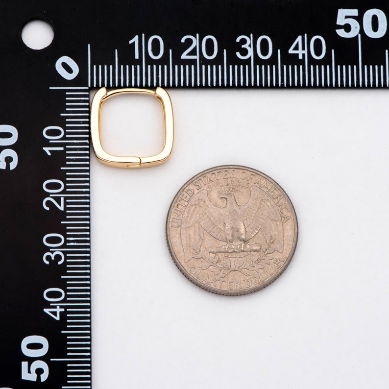 Pu&ograve; includere: Un orecchino a cerchio quadrato in oro che misura circa 1,25 cm di diametro, accanto a una moneta da 25 centesimi di dollaro americano per il confronto delle dimensioni.