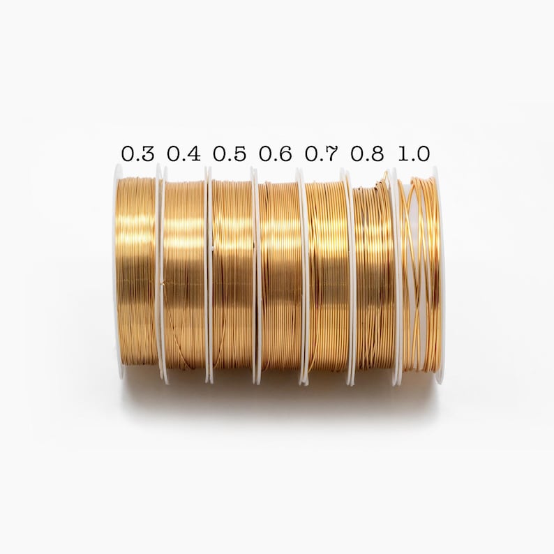 May include: Seven spools of gold wire, each with a different diameter, labeled 0.3, 0.4, 0.5, 0.6, 0.7, 0.8, and 1.0.