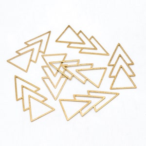May include: A collection of gold-colored triangle-shaped jewelry findings. The findings are open-framed and arranged on a white surface. The triangles are of varying sizes and are suitable for jewelry making and crafting projects.