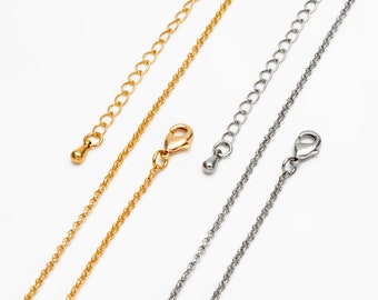 May include: Two delicate chains, one gold and one silver, with lobster clasps and extender chains. The chains are laid out on a white background.