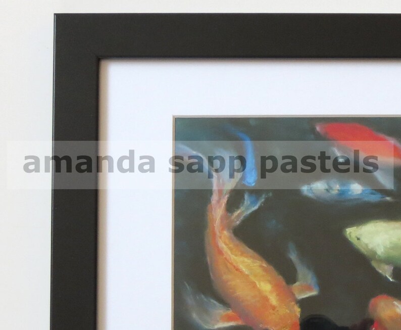 May include: A framed pastel drawing of colorful koi fish swimming in a dark pond. The fish are orange, red, blue, and white. The frame is black with a white mat.
