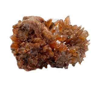 May include: A cluster of orange and brown crystals with a rough, textured surface. The crystals are arranged in a random, organic pattern, creating a unique and interesting display.