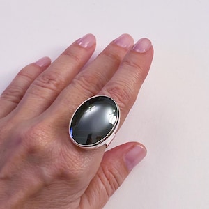 May include: A silver ring with a large oval black gemstone.