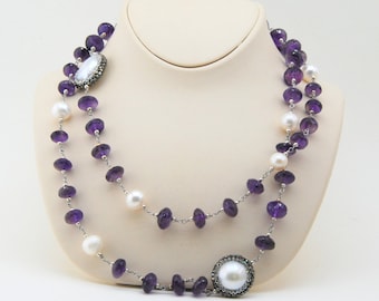 May include: A double strand necklace with amethyst and pearl beads. The necklace features two large pearl accents with silver bezels.