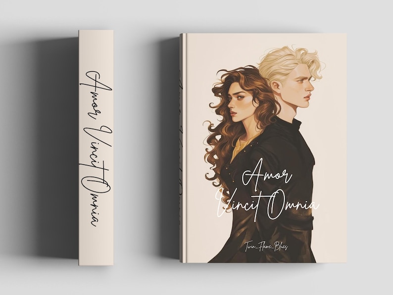 May include: A book with a cream-colored cover and spine. The cover features a romantic illustration of a man and woman with the title "Amor Vincit Omnia" in cursive. The spine also displays the title.