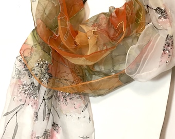 May include: A sheer silk scarf with a floral print in shades of orange, green, and white. The scarf has a delicate, flowing design and features a black inscription in the lower right corner.