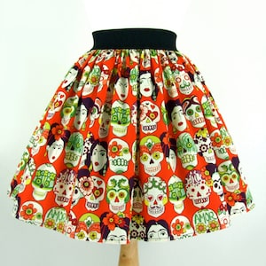 Falda elástica acampanada con caras y calaveras de Frida en color naranja
