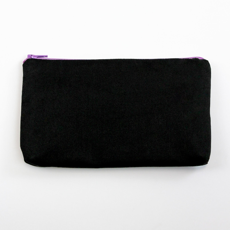 May include: A black zippered pouch with a purple zipper.