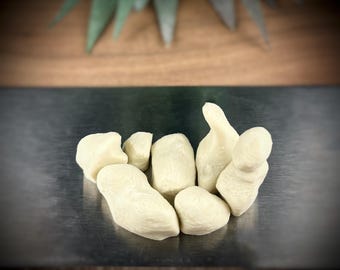 May include: A group of six off-white, textured, irregularly shaped silicone molds.