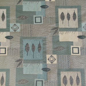 May include: A fabric swatch with a geometric pattern in shades of blue, brown, and beige. The pattern features squares, rectangles, and leaves.