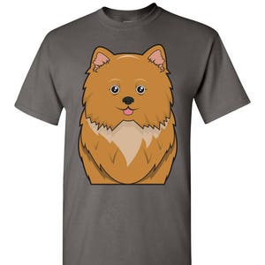 Peut inclure: Un t-shirt gris foncé avec une image de dessin animé d'un chien orange moelleux avec des oreilles roses et une langue rose qui sort.