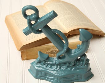 Tope de puerta con forma de ancla, hierro fundido, color turquesa, decoración náutica.