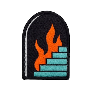 Pode incluir: Patch bordado com fundo preto em forma de arco e borda branca. Apresenta chamas laranja sobre um design de escada turquesa. Um acessório distintivo.