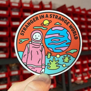 Stranger in a strange world sticker. Astronaut on strange planet sticker.