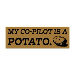 May include: A rectangular sticker with the text "MY CO-PILOT IS A POTATO." in black letters on a tan background. A black and white illustration of a potato is on the right side of the sticker.