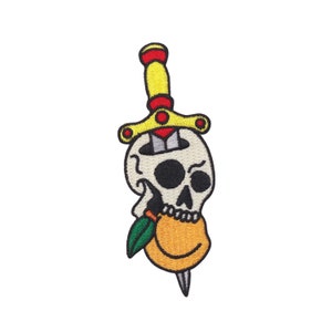 May include: An embroidered patch featuring a white skull with a black dagger piercing through its head. The dagger has a yellow handle with a red tip. The skull is biting into a yellow orange with a green leaf.
