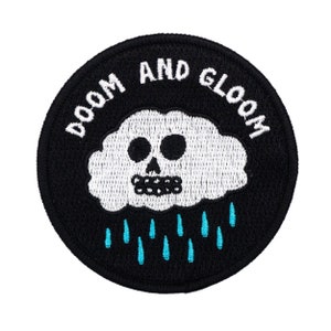 May include: Black and white embroidered patch with a skull-shaped cloud and the text "Doom and Gloom" in a circle. Blue raindrops fall from the cloud.