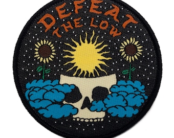 May include: Black embroidered patch with a skull, sun, and sunflowers. The text "DEFEAT THE LOW" is written in a circular pattern around the skull.