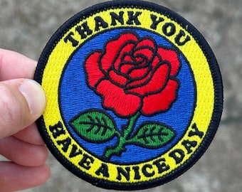 May include: A yellow, blue, and red embroidered patch with a rose and the text "Thank You Have A Nice Day".