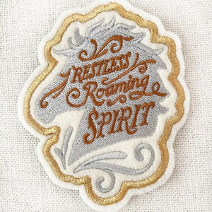 May include: A white and gold embroidered patch with a horse head silhouette and the text "A Restless Roaming Spirit".