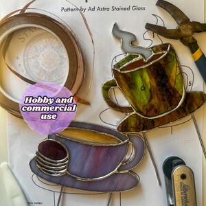 May include: A stained glass pattern for making coffee cup plant stakes. The pattern includes two coffee cups with steam coming from the top, one with a purple and one with a green and brown design. The pattern is labeled "Hobby and commercial use".