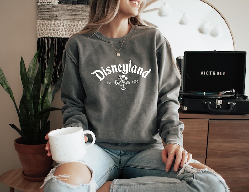 a woman sitting on a table holding a coffee mug