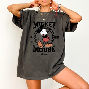 a woman wearing a mickey mouse t - shirt