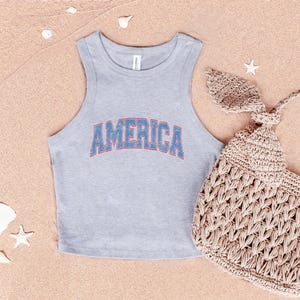 a bag and a tank top on a beach