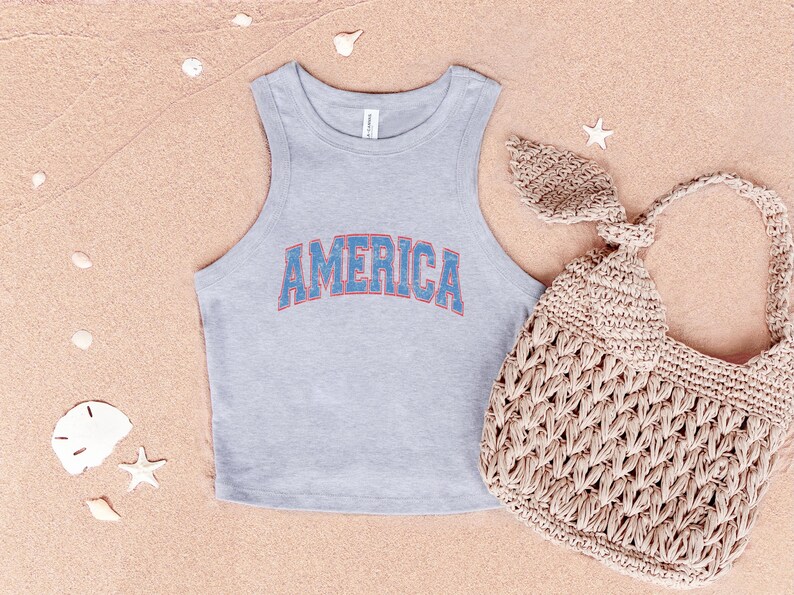 a bag and a tank top on a beach