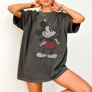 a woman wearing a mickey mouse t - shirt