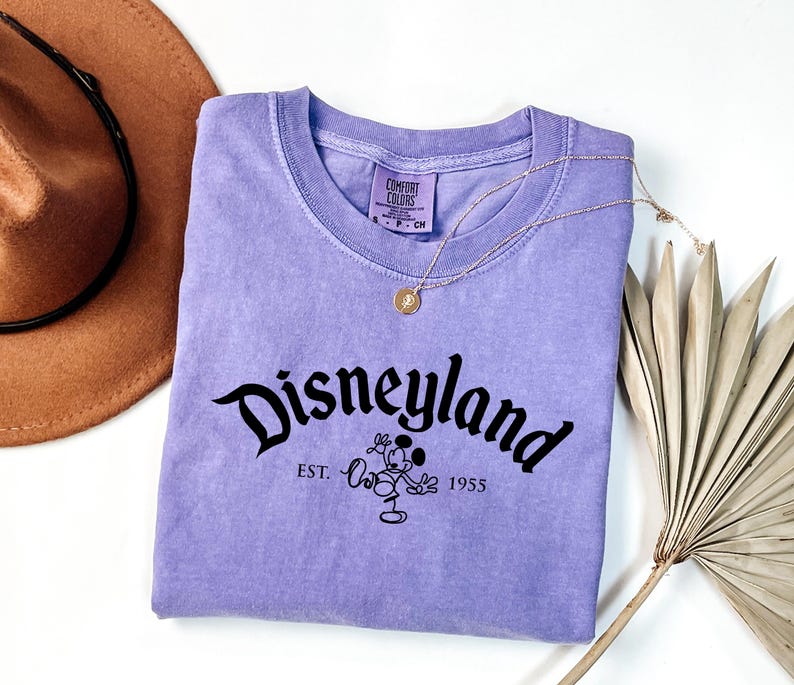 a t - shirt that says disneyland next to a hat