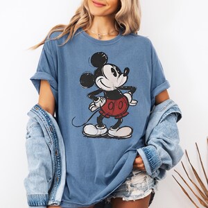 a woman wearing a mickey mouse t - shirt