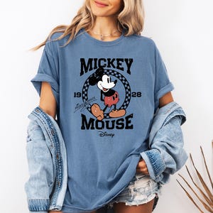 a woman wearing a mickey mouse t - shirt