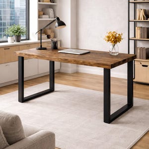 May include: A rectangular desk featuring a thick, dark brown wooden top with a visible grain pattern, supported by two sturdy, black metal U-shaped legs. The desk surface is clear, providing a spacious workspace for various office tasks.