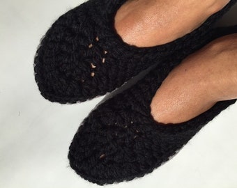 May include: Pair of black crocheted slippers. The slippers have a simple, open-weave design.