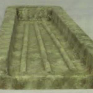 May include: A green concrete trough with five parallel grooves running along the length of the trough.