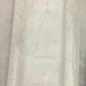 May include: A white rectangular tray with two raised edges on either side. The tray is made of a smooth, slightly textured material.