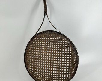 Cesta antigua de mimbre tejida a mano con asa, en excelente estado.