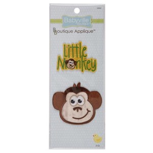 May include: A package of two iron-on appliques featuring a brown monkey face and the text "Little Monkey" in green and yellow letters on a yellow background.
