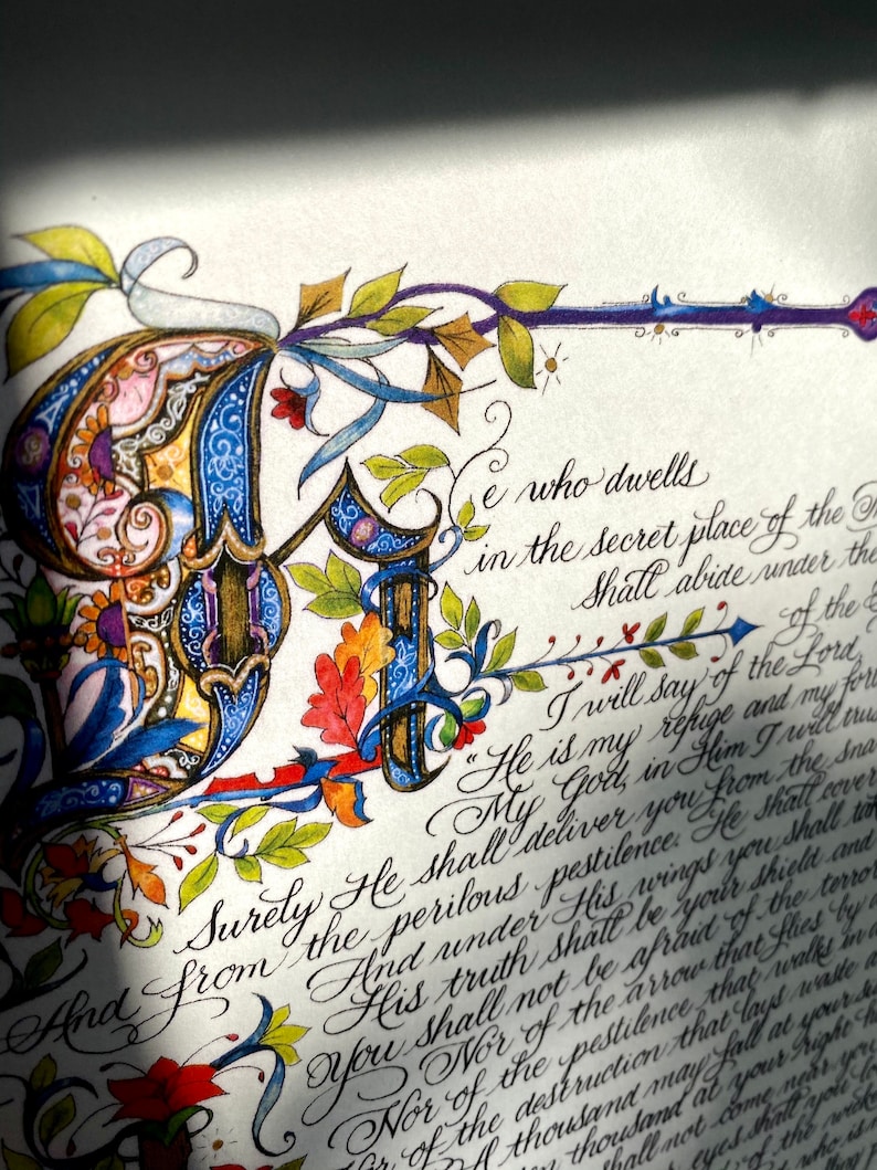 Puede incluir: Un primer plano de un manuscrito iluminado pintado a mano con una letra inicial decorativa "A" en azul, dorado y rojo. El texto dice: "Ciertamente &Eacute;l te librar&aacute; de la pestilencia peligrosa. &Eacute;l te cubrir&aacute; bajo su verdad, &Eacute;l ser&aacute; tu escudo y tu ayuda contra el terror. No tendr&aacute;s miedo de la flecha que vuela de d&iacute;a, ni de la pestilencia que anda en la oscuridad, ni de la destrucci&oacute;n que asola al mediod&iacute;a. Mil pueden caer a tu lado, y diez mil a tu derecha, pero no se acercar&aacute; a ti."