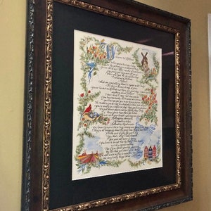 May include: A framed calligraphic artwork with a black mat and a brown wood frame. The artwork features a handwritten poem with illustrations of birds, flowers, and a windmill. The poem begins with the words "Welcome to the Wildwood".