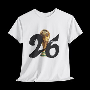 Puede incluir: Camiseta blanca con un gr&aacute;fico en blanco y negro del trofeo de la Copa Mundial de la FIFA y el n&uacute;mero 26.