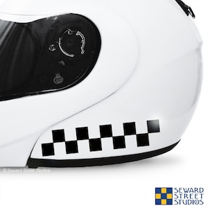 May include: A white motorcycle helmet with a black and white checkered stripe decal on the side.
