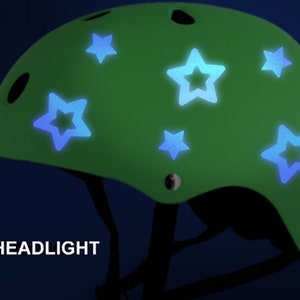 May include: Green bicycle helmet with blue glow-in-the-dark star stickers. The helmet has a black strap and a headlight.