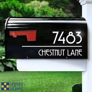 K&ouml;nnte beinhalten: Schwarzer Briefkasten mit einer wei&szlig;en Nummerntafel mit der Aufschrift "7483 CHESTNUT LANE".