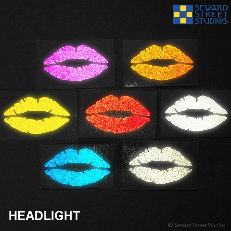 May include: Six different colored lips stickers that glow in the dark. The colors are pink, orange, yellow, red, blue, and white. The stickers are on a black background.  Seward Street Studios.