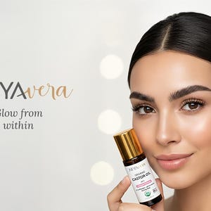 Puede incluir: Una mujer sostiene un peque&ntilde;o frasco de aceite de ricino org&aacute;nico con tapa dorada. El frasco lleva la etiqueta "NIYAvera" y "Glow from within". El fondo es blanco suave y borroso con luces bokeh.