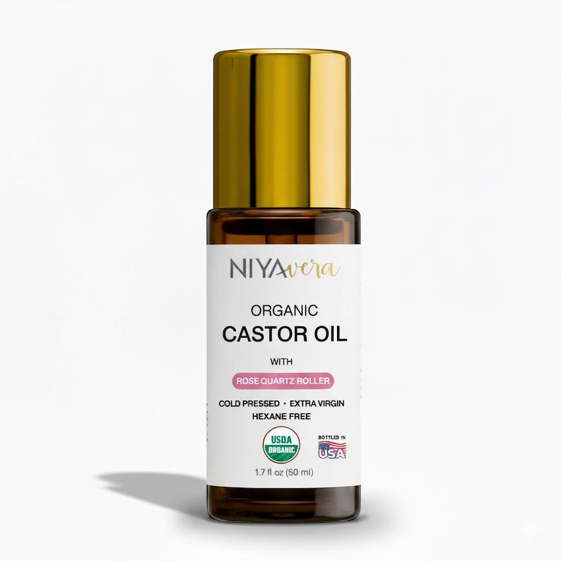 Puede incluir: Una botella de vidrio marr&oacute;n de aceite de ricino org&aacute;nico con una tapa dorada. La etiqueta dice "NIYAvera ORGANIC CASTOR OIL" con "ROSE QUARTZ ROLLER" y "50 ml". El producto es prensado en fr&iacute;o, extra virgen y sin hexano.