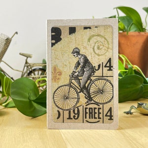 Mini cahier avec collage de bicyclettes sur la couverture, poche arrière et 48 pages légèrement quadrillées. Le tout recyclé. Cousu à la main avec du fil de lin. image 1